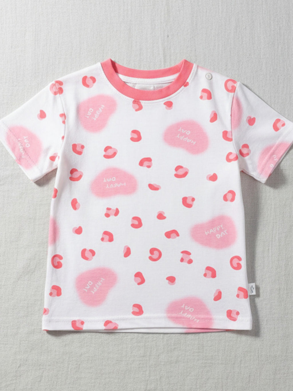 White t-shirt with pink heart patterns on a light gray background