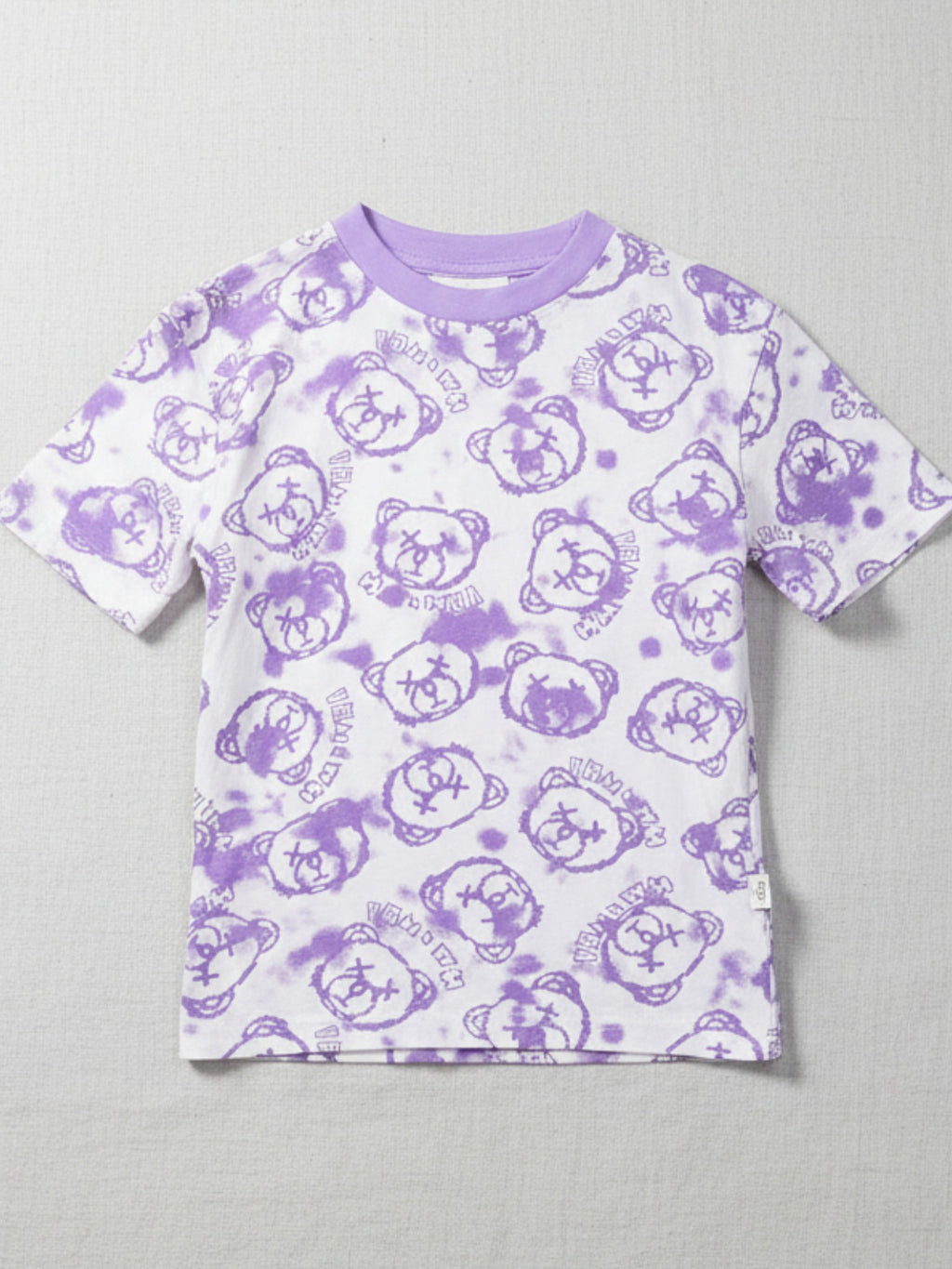 Purple t-shirt with teddy bear pattern on a gray background
